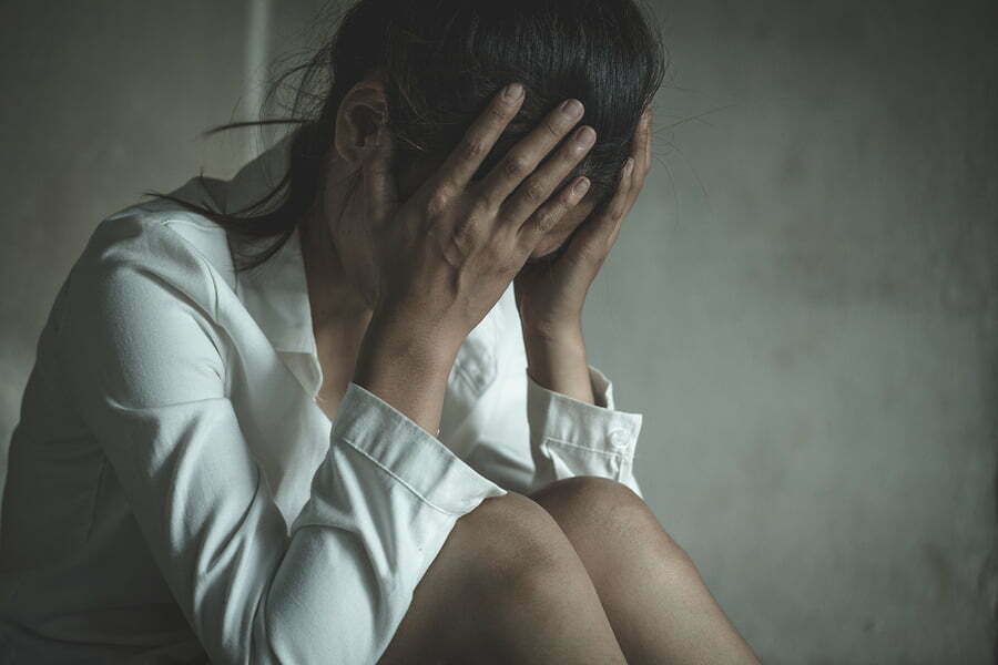 substance abuse and domestic violence. An image of a woman with her head in her hands, insinuating distress.