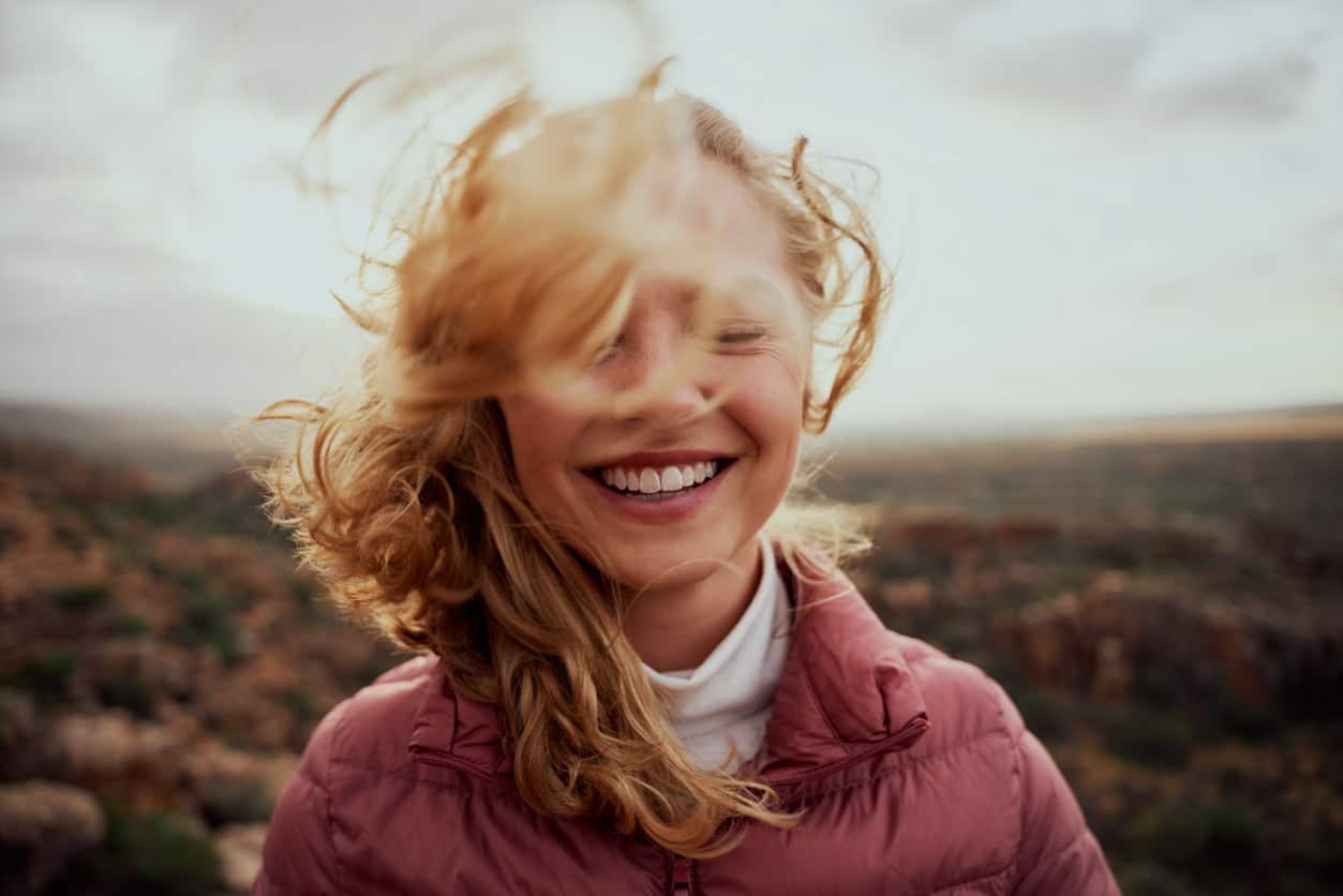 Girl in countryside, wind blowing hair into her face
